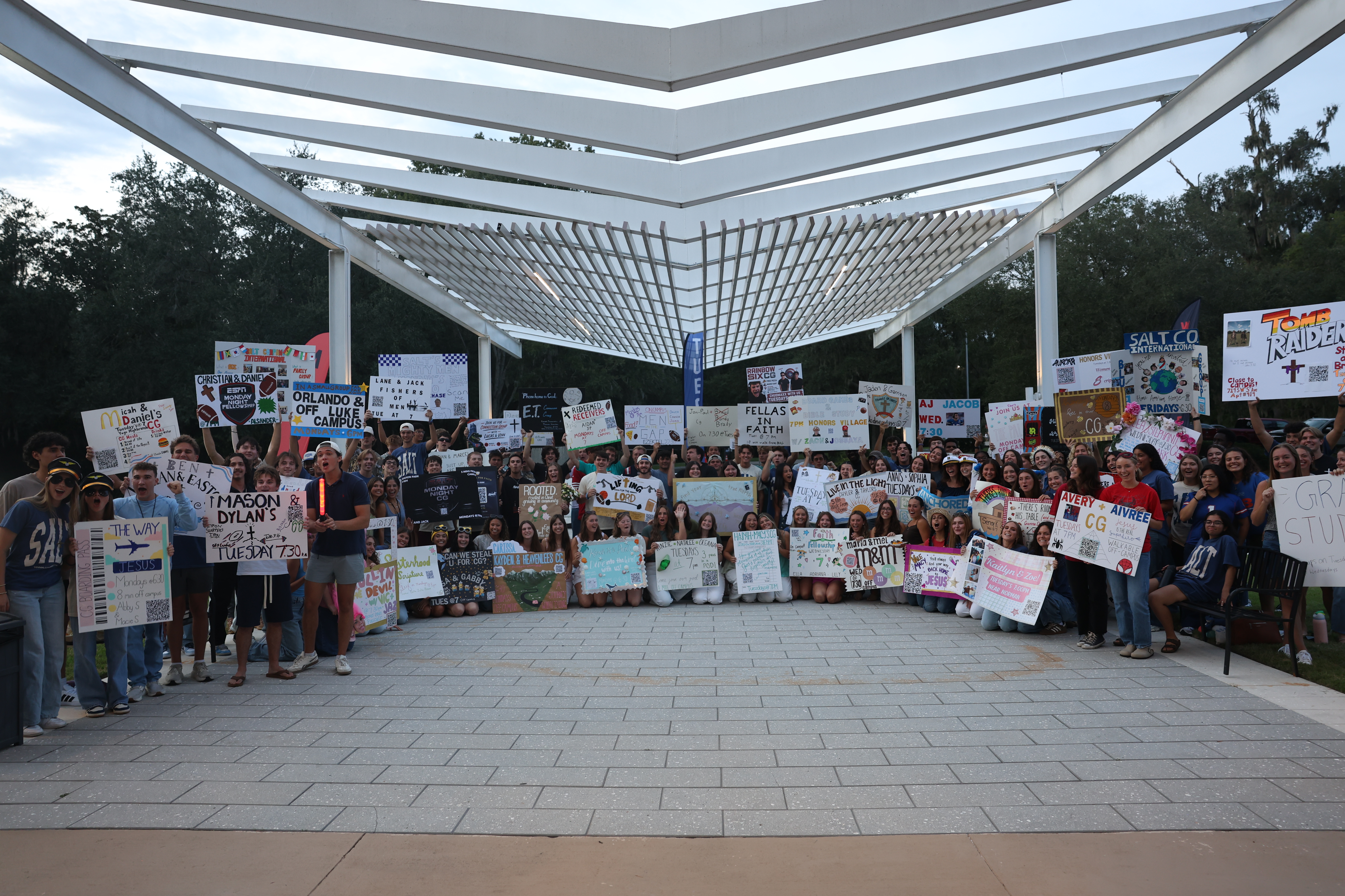 Students holding a 'There's room for you' sign at a Salt Company gathering