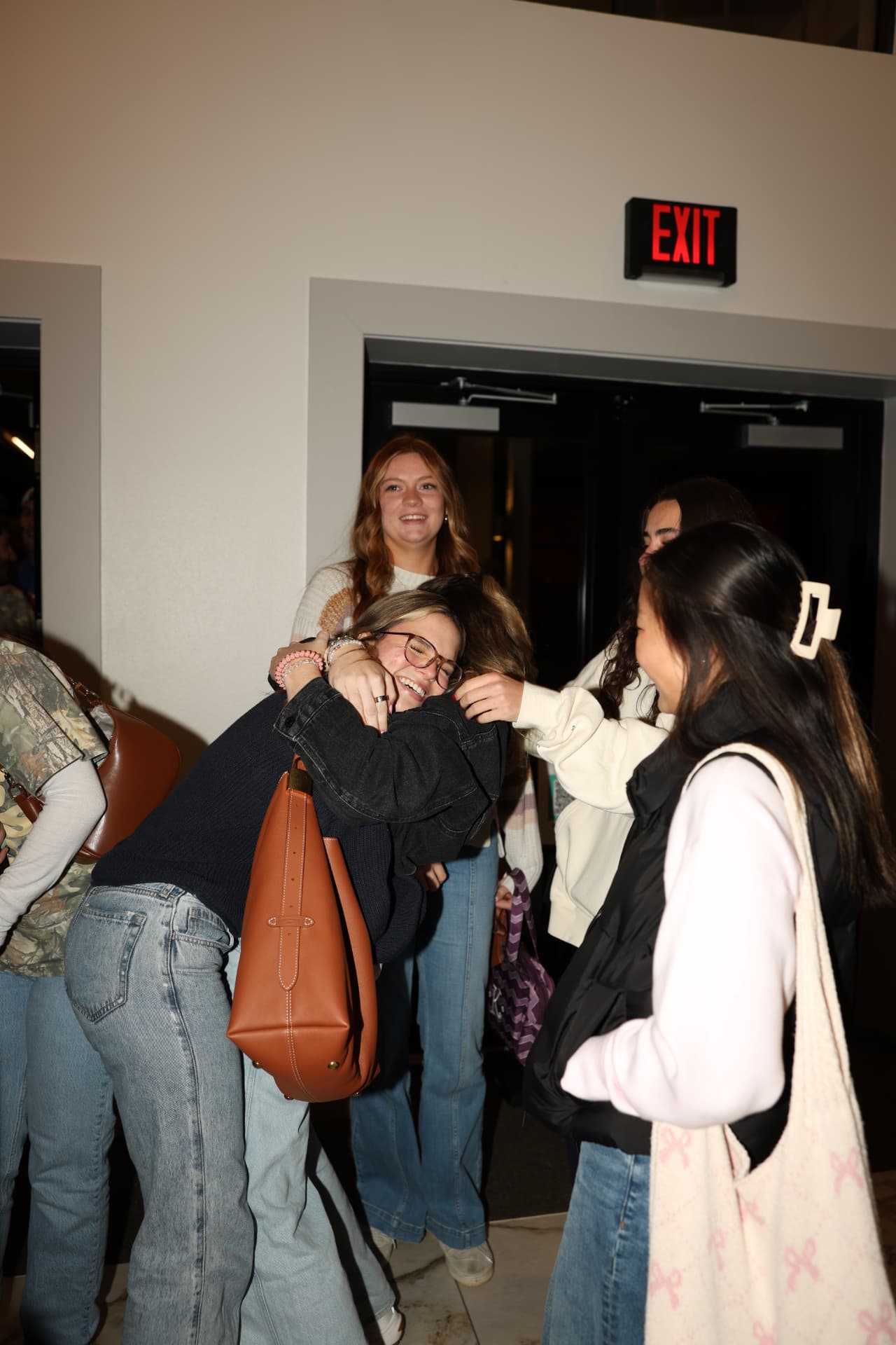Students hugging in the lobby after a gathering